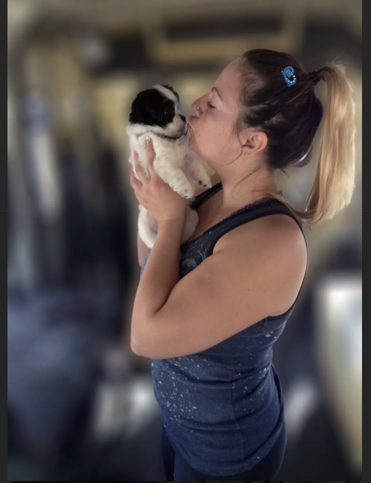 Eco Paw Spa groomer cuddling a small puppy